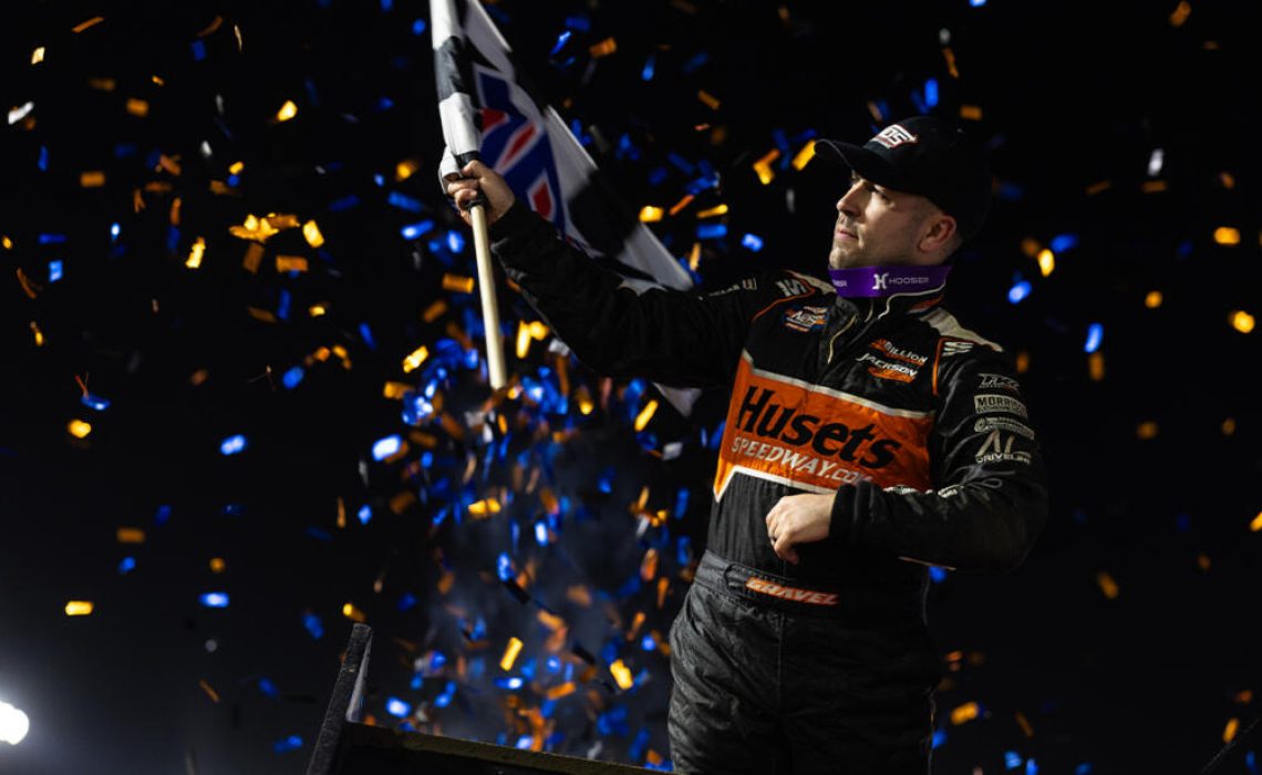 David Gravel celebrating with a wing dance and waving a checkered flag